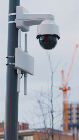 Vertical-Video-Showing-Close-Up-Of-Surveillance-Camera-Outside-Buildings-In-London-UK